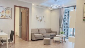 A modern living room with a sofa, ottoman, and round table.
