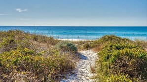A sandy path leading to a beach with clear blue water and sparse vegetation. - Sea Lover - 5 BR Gulf View Getaway with Pool, Pets (Panama City BeachF)
