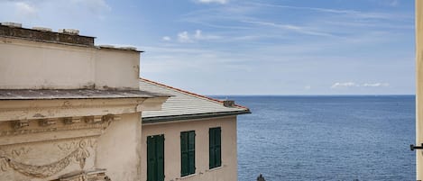 Un bâtiment situé sur la côte, doté d’une architecture classique, d’un balcon et offrant une vue sur la mer.