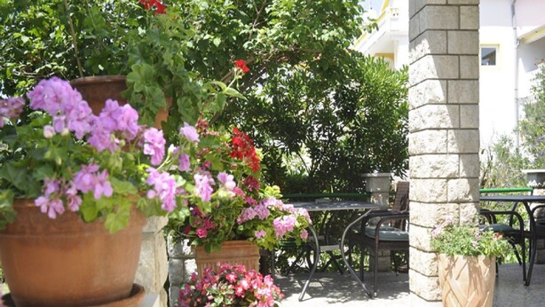 A patio area with outdoor seating and potted plants. - Apartments Profaca (Rab)