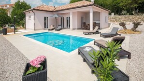 A modern villa with a swimming pool, outdoor seating, and a garden. - Villa Tomicich (Rasa)