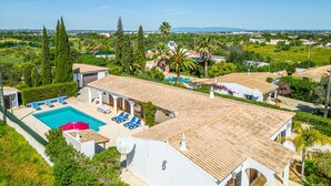 A residential area with a swimming pool, lounge chairs, and a view of the surrounding landscape. - Villa Brid's Countryside Retreat (Albufeira)