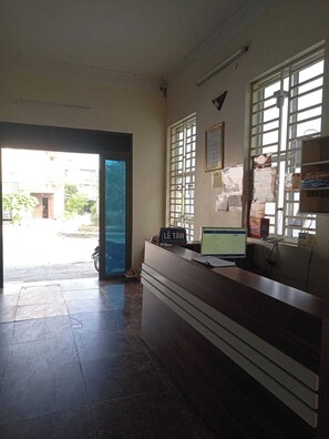 A reception area with a desk, computer, and a sign reading "LE TAN". - Minh Long Guesthouse - Quang Truong (Thuc Phan)