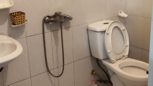 A small bathroom with a toilet, a sink, and a shower. - Minh Long Guesthouse - Quang Truong (Thuc Phan)
