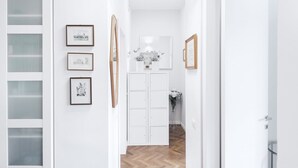 A hallway with white walls, framed pictures, and a white door. - Easylife - Residential apartment on Navigli area (Milano)