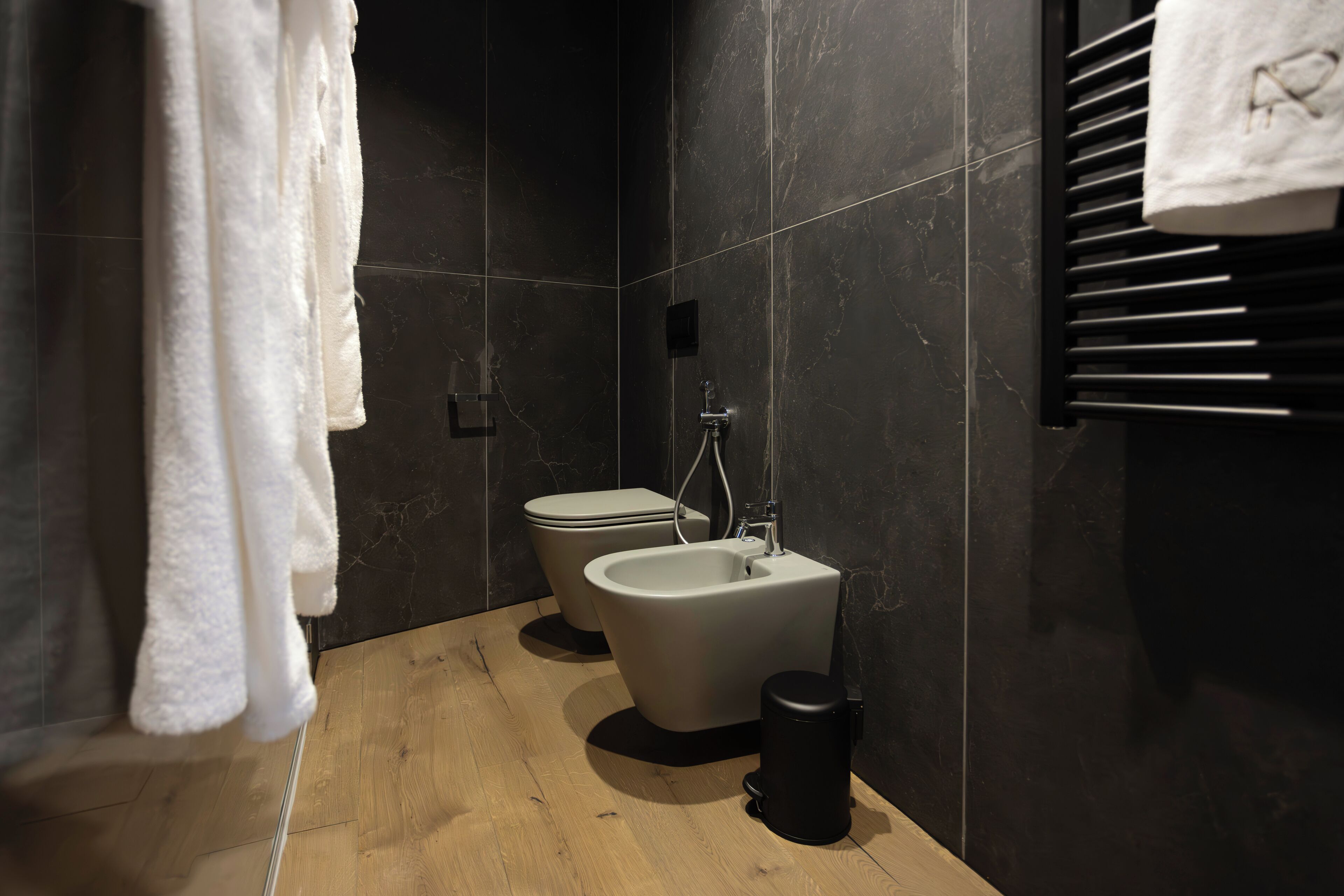 A modern bathroom with a bidet, a toilet, and a towel rack.