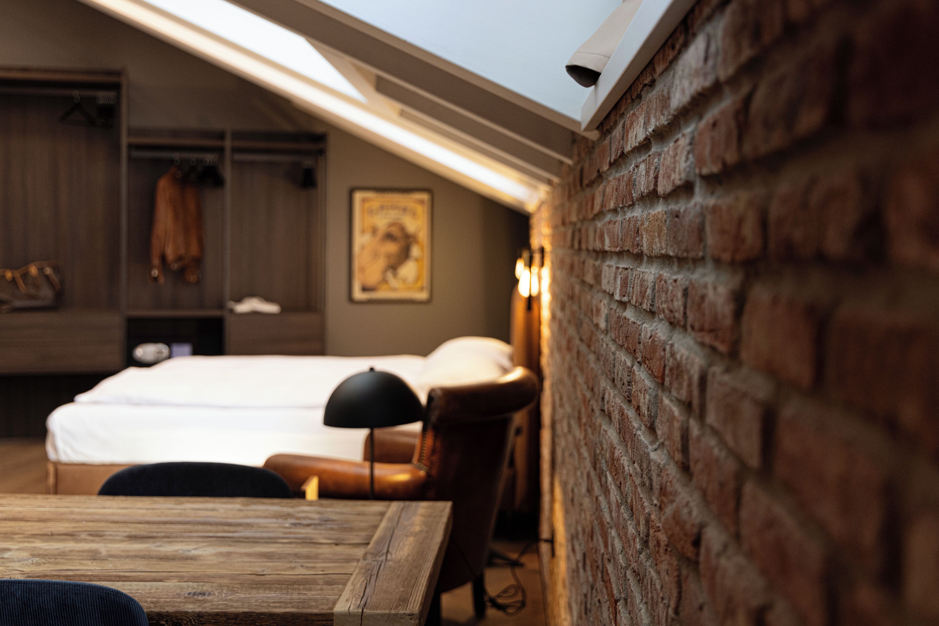 Um quarto aconchegante com cama beliche, mesa de madeira e parede de tijolos.