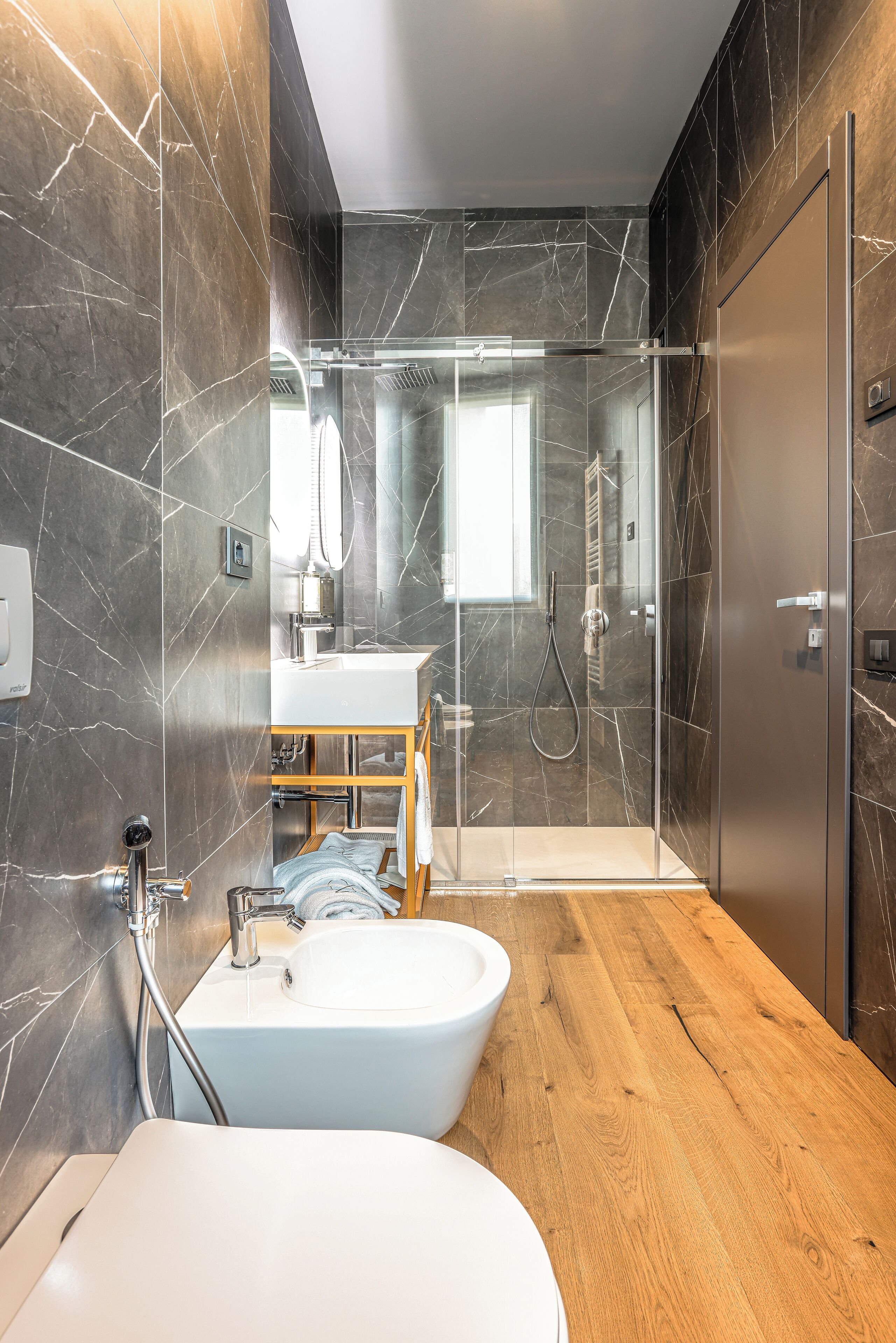 A modern bathroom with a freestanding bathtub, a glass-enclosed shower, and a wooden vanity.