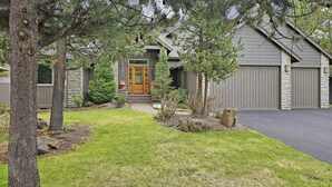 A residential property with a stone facade, a wooden front door, and a garage. - 7 Titleist-Sunriver, Oregon: Woodlands Golf Course View, Air Conditioning, SHARC Aquatics, BBQ, WiFi, Mt. Bachelor, Deschutes River, Tennis, Bike Paths (Sunriver)