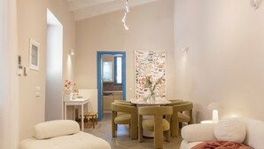 A modern living room with a round wooden coffee table, two sofas, a dining table with chairs, and a kitchen in the background. - Villa Plaka 3BR 9ppl Private Yard, 200m from Acropolis Metro&Museum (Athina)