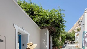 A woman walking down a stone staircase in a narrow street with white walls and a blue door. - Villa Plaka 3BR 9ppl Private Yard, 200m from Acropolis Metro&Museum (Athina)