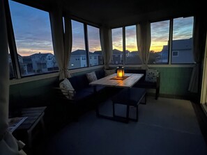A room with a large window, a table with a candle, and a sofa. - 6BR ocean-side Corolla retreat with pool, hot tub, and beach access. CP-47 (Corolla)