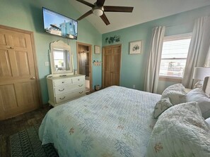 A bedroom with a bed, dresser, ceiling fan, and a television mounted on the wall. - 6BR ocean-side Corolla retreat with pool, hot tub, and beach access. CP-47 (Corolla)