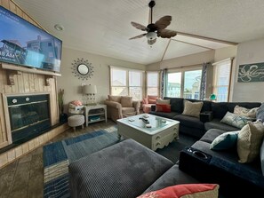 A living room with a television, ceiling fan, and various seating arrangements including a sofa and armchairs. - 6BR ocean-side Corolla retreat with pool, hot tub, and beach access. CP-47 (Corolla)