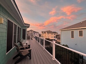 A wooden deck with chairs, a railing, and a view of neighboring houses. - 6BR ocean-side Corolla retreat with pool, hot tub, and beach access. CP-47 (Corolla)