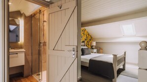 A bedroom with a bed, a bedside table, and a window.