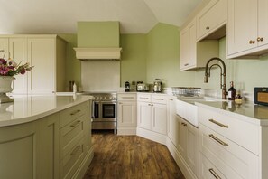 Enjoy cooking in this kitchen with white cabinetry, stainless steel oven, and a spacious island.