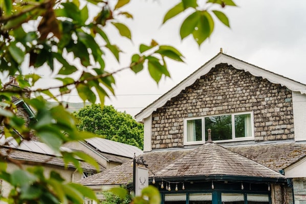 A stone building with a gabled roof and a window.