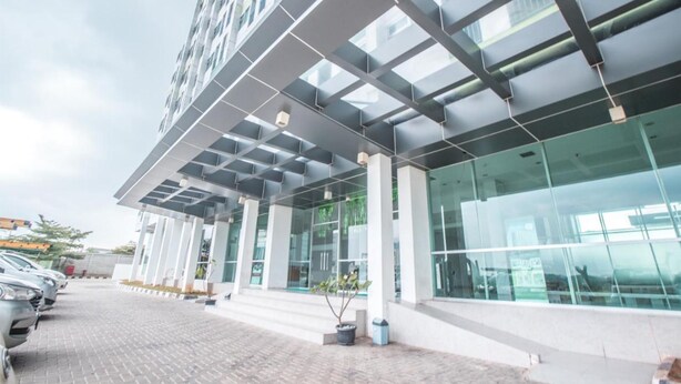 A modern building with a glass facade, large windows, and a covered entrance area.