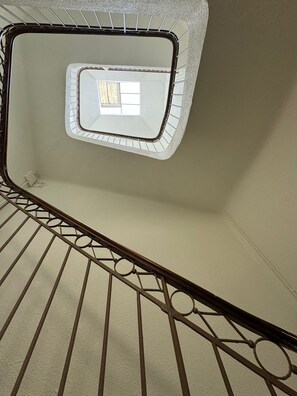 Staircase with a geometric-patterned railing and a small window.