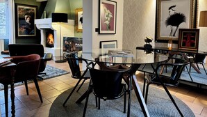 A modern dining area with a glass table, black chairs, and a fireplace. - La Terrasse du 10 Honfleur (Honfleur)