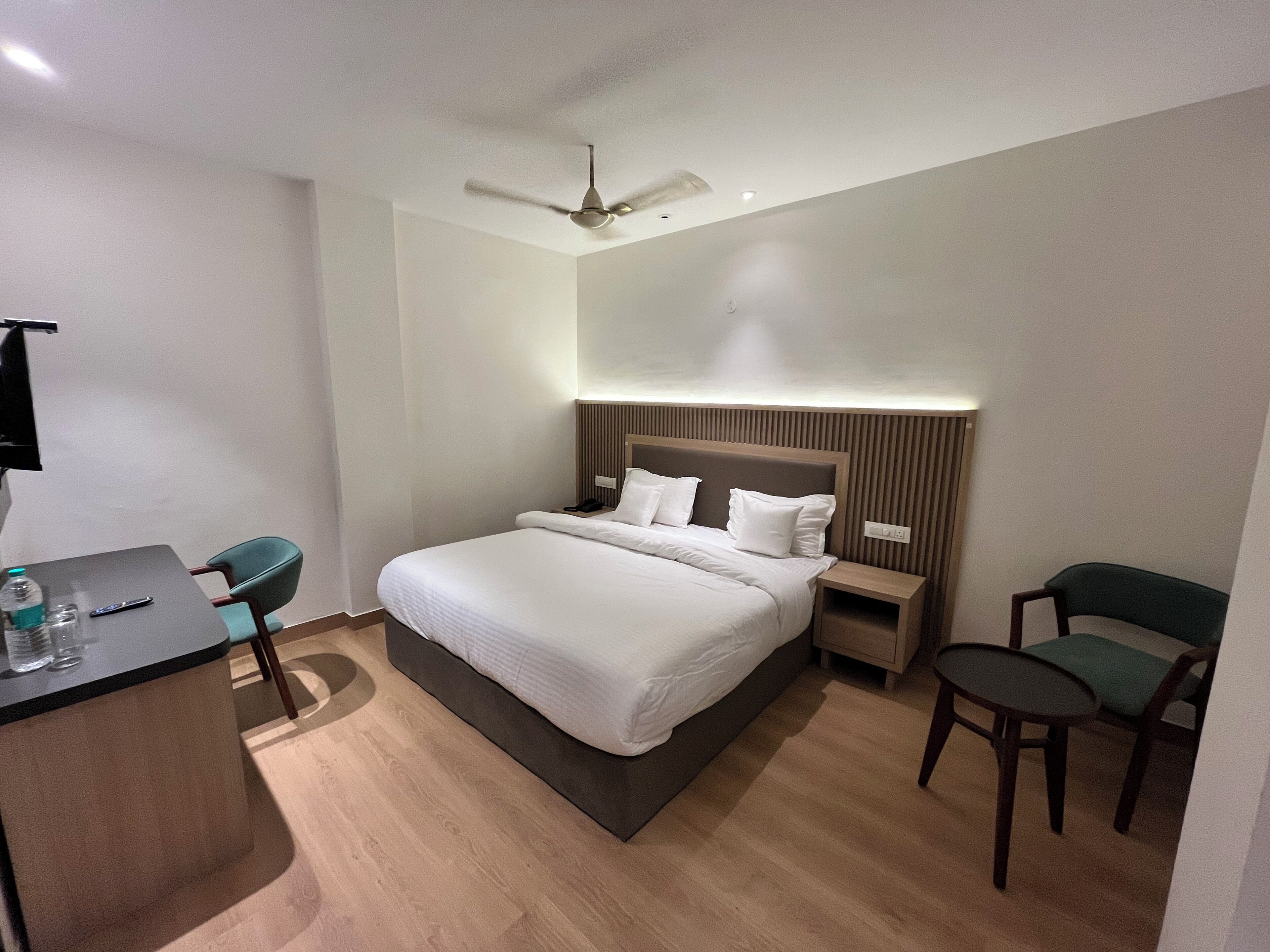 Una habitación de hotel moderna con una cama grande, un escritorio y dos sillas.