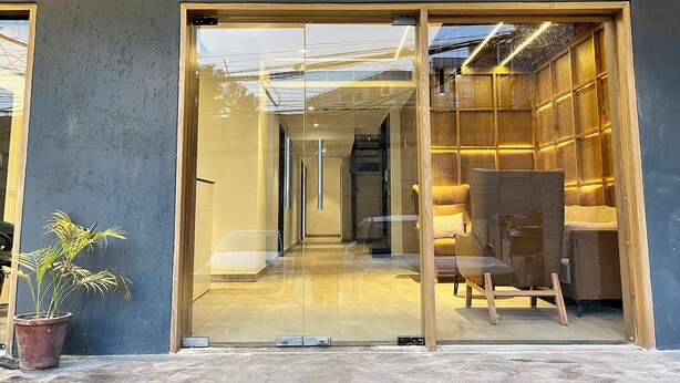 Un intérieur moderne avec une porte vitrée donnant sur un espace salon aménagé avec des meubles en bois.