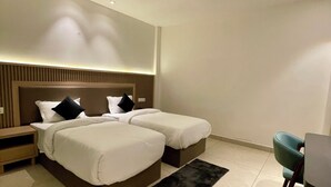 Une chambre d’hôtel moderne avec un grand lit, un ventilateur de plafond et un petit bureau.