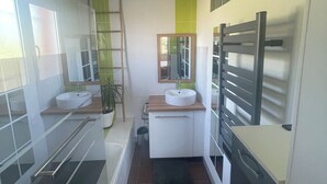 A modern bathroom with two sinks, a bathtub, and a shower. - Aux Aigrettes (Gousse)