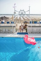 Una piscina al aire libre de temporada, tumbonas