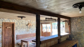 A rustic interior with a stone wall, wooden bench, and a fireplace. - Holiday Home Jela (Gospic)