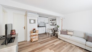 A modern living room with a sofa, a TV, and a wooden floor. - Residence San Giorgio by Wonderful Italy (Toscolano Maderno)