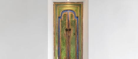 Une porte étroite et haute, au design simple et rectangulaire, avec un petit bouton de porte rond.
