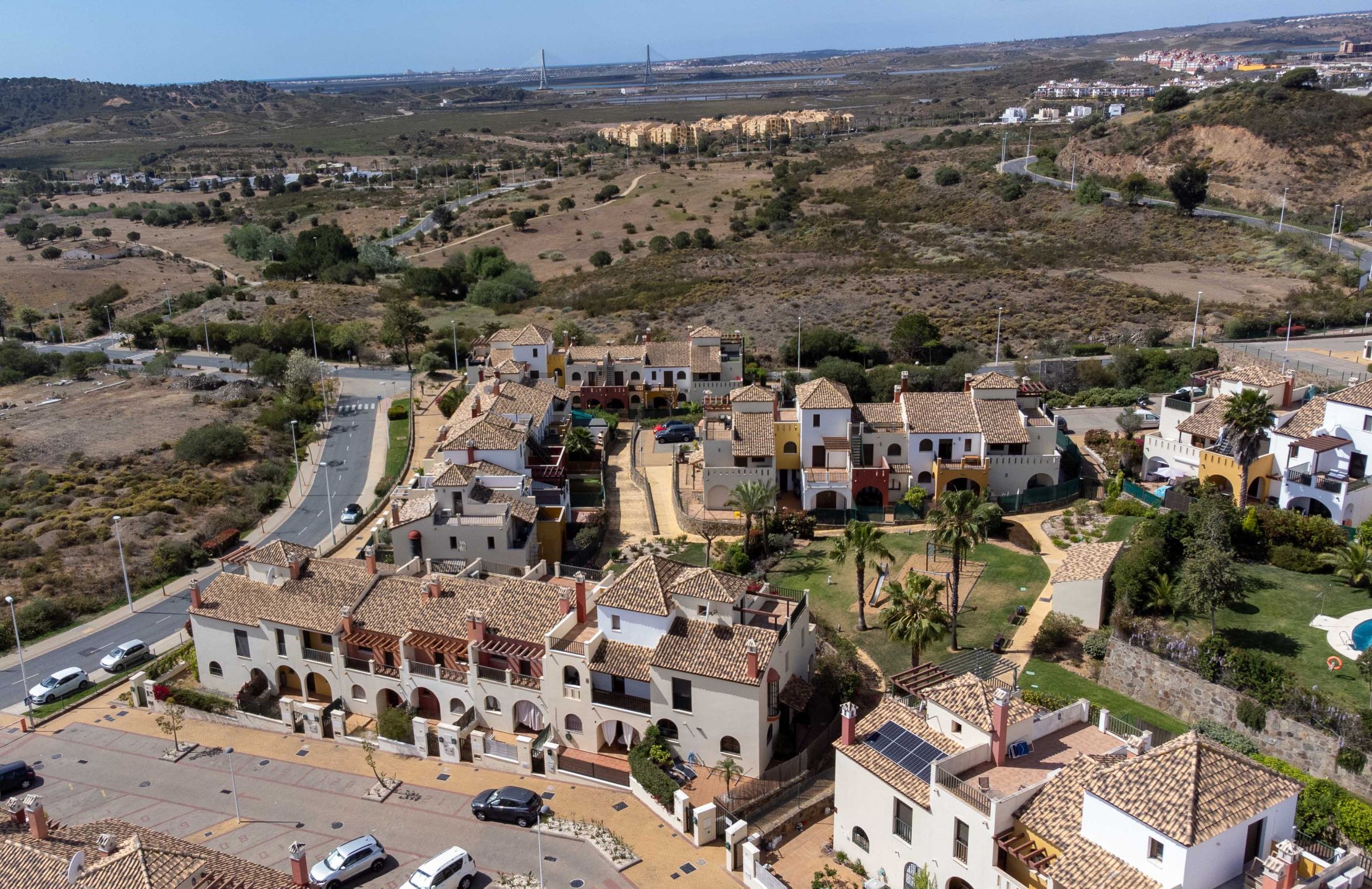 A coastal town with traditional architecture, a main road, and a view of the sea.