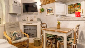 A cozy room with a fireplace, a television mounted on the wall, and a window with a colorful stained glass design. - C'era una volta in centro by Wonderful Italy (Desenzano del Garda)