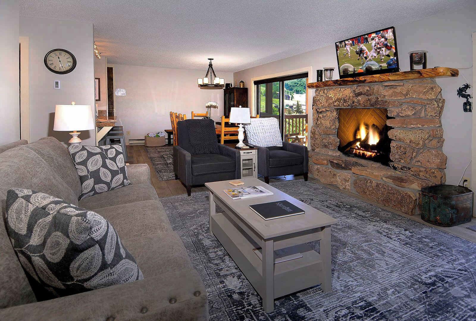 A living room with a fireplace, a sofa, a coffee table, and a television.