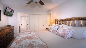 A bedroom with a bed, a wooden dresser, a television mounted on the wall, and a ceiling fan. - Ponderosa Place, Walk to slopes, Hot tub! (Mt. Crested Butte)