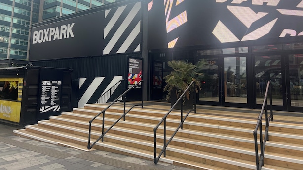 A modern building with a sign reading "BOXPARK" and a staircase leading to the entrance. - 3 Bedroom House in London - Private Garage - Wi-fi (Croydon)