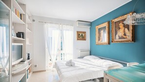 Een slaapkamer met een bed, een bureau, een boekenkast en een raam met gordijnen.