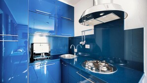 Een moderne keuken met blauwe kastjes, roestvrijstalen apparatuur en een inbouwoven.