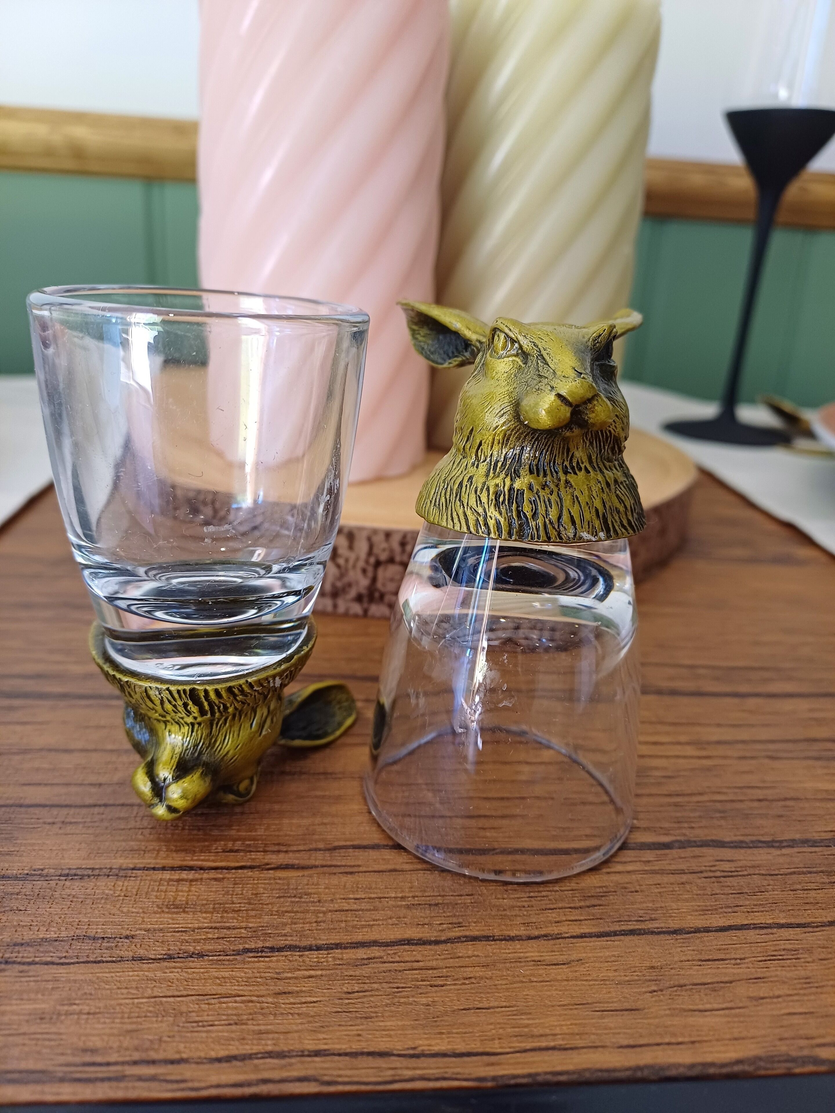 Two glass vases with animal designs on a wooden surface.