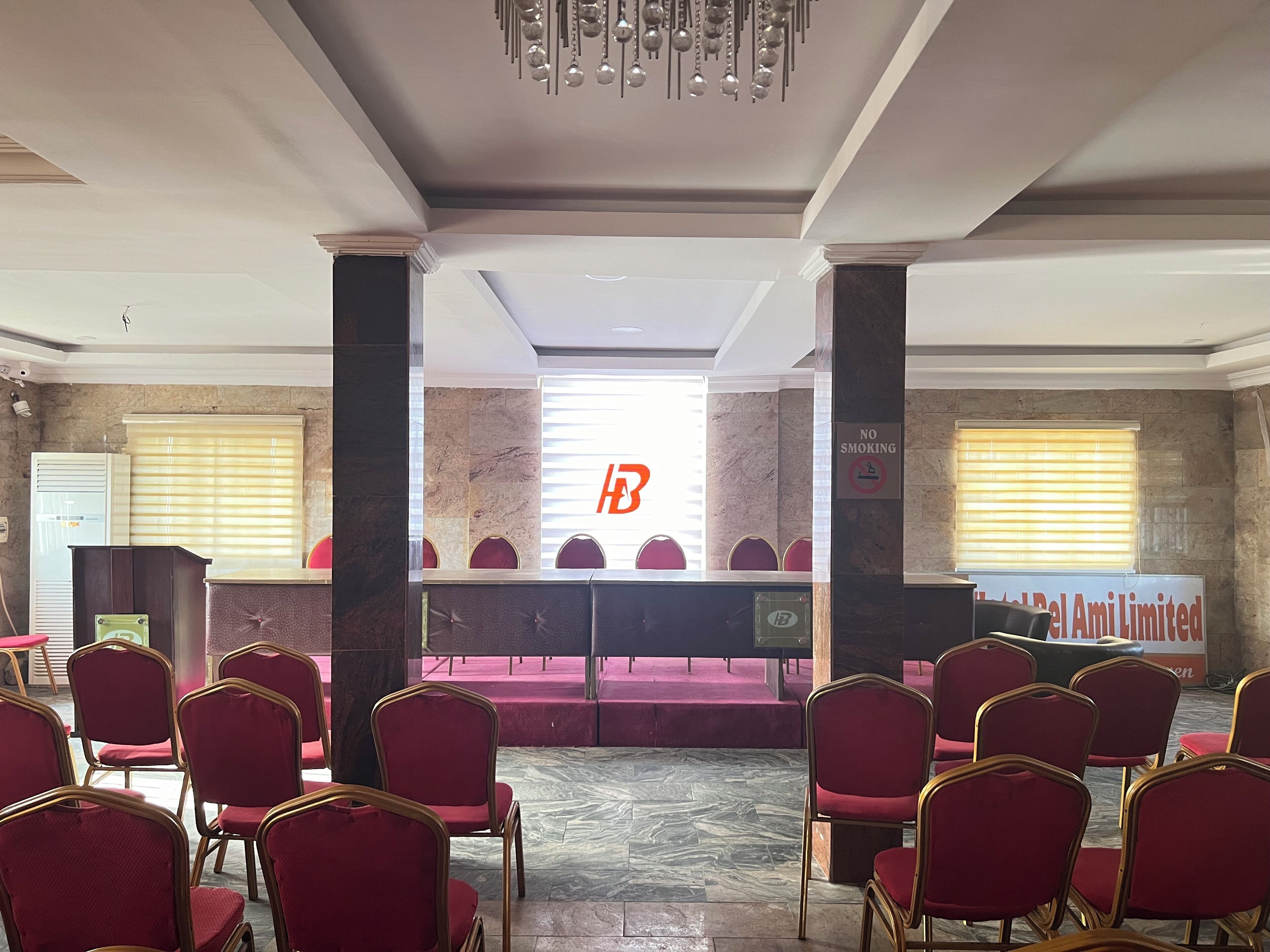 A conference room with a long table, red chairs, and a 'No Smoking' sign.
