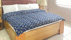 Un dormitorio con cama, mesita de noche, espejo y aire acondicionado.