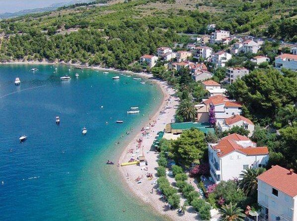 A coastal town with a beach, boats, and houses. - Apartment Stipic Omis (Omis)