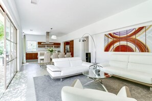 Spacious living area with a sofa, dining table, and floor lamp.