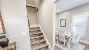 A modern interior with a staircase leading to a dining area.