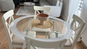 A round glass table with white chairs and a woven placemat. - Urban Luxury Apartment Zagreb (Zagreb)