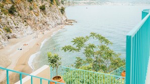 A coastal view from a balcony with a turquoise railing, overlooking a sandy beach with people and a calm sea. - Villa San Michele by Elite Villas (Cetara)