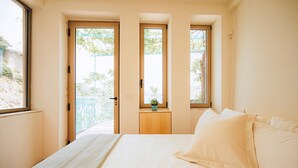 A bedroom with a bed, a window, and a door leading to an outdoor balcony. - Villa San Michele by Elite Villas (Cetara)
