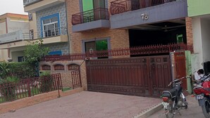 A multi-story building with a gated entrance, a motorcycle parked in front, and a sign indicating the name 'Lifelong Learners'. - Sapphire Inn (Islamabad)